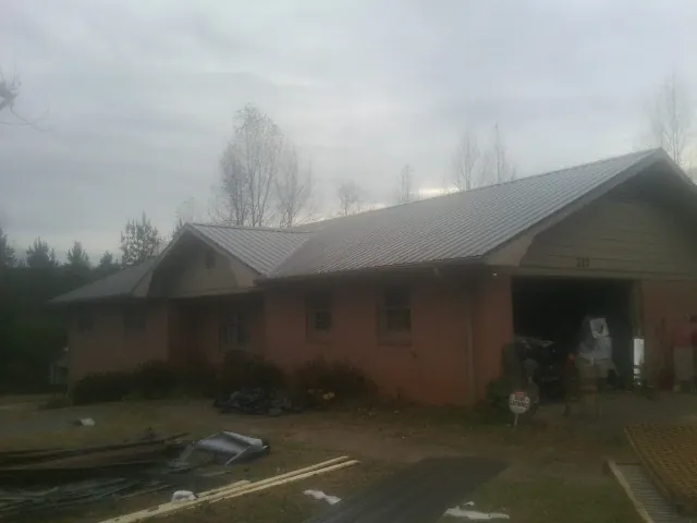 Gray metal roof on a stucco house with an attached garage in Jefferson